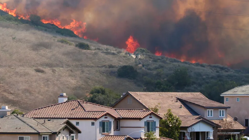 Wildfire burning on a hillside above homes in Southern California